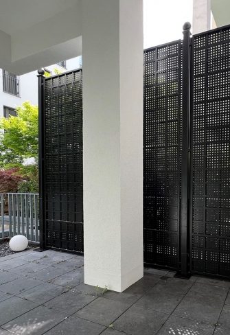 The Gropius Iron Railing Privacy Screen by Classic Garden Elements installed on a balcony