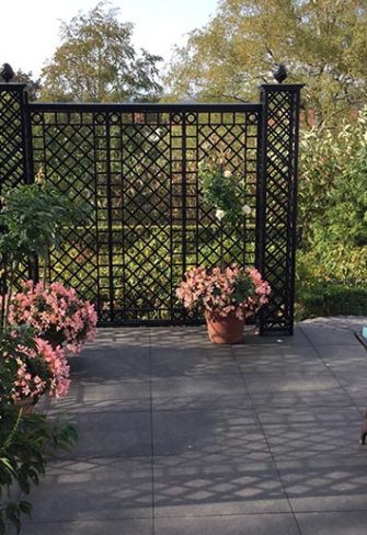 The Wessling Treillage Set by Classic Garden Elements in black, installed at the edge of a patio