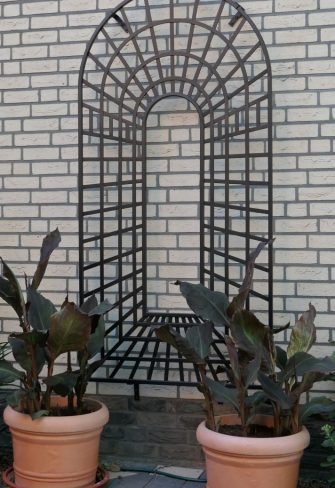 Trompe-l’œil Perspective Trellis Panels by Classic Garden Elements installed on a brick wall