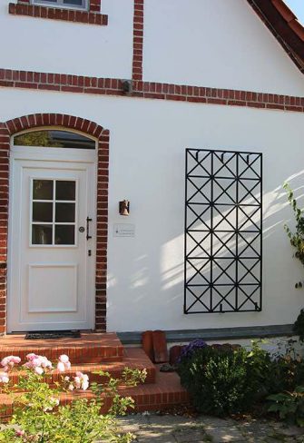 The Ravenna Metal Wall Trellis installed on a white house façade