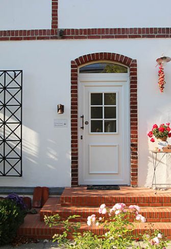 The Ravenna Metal Wall Trellis by Classic Garden Elements on a white house façade