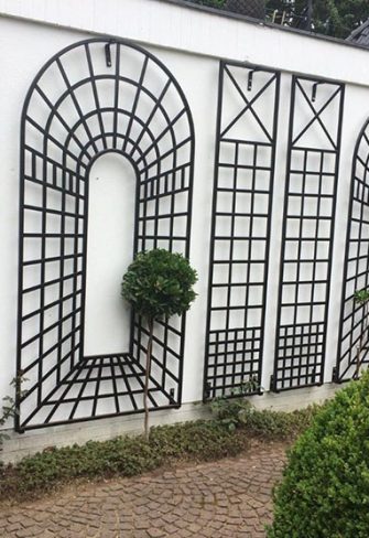 The Croome Treillage Panel Set by Classic Garden Elements in black installed on a white garden wall