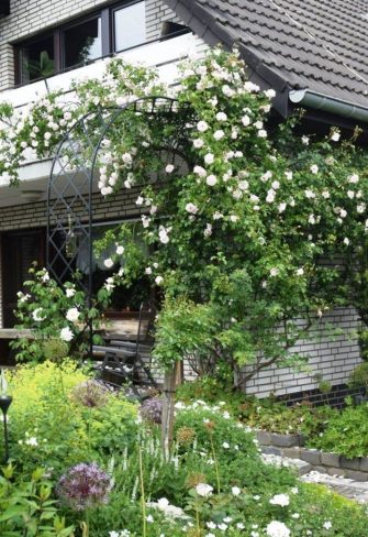 The Half-Round Garden Arch Bagatelle by Classic Garden Elements covered in white roses