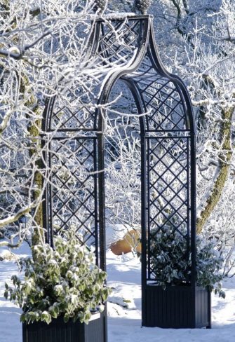 Freestanding Brighton Garden Arch with two Versailles planters on a snowy day in Steinfurt