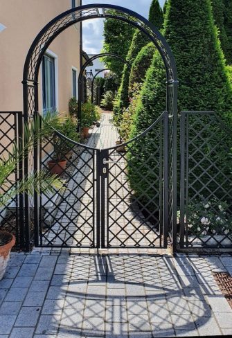 Front view of the Portofino Garden Arch with Gate and Fence in a classic Tuscan garden