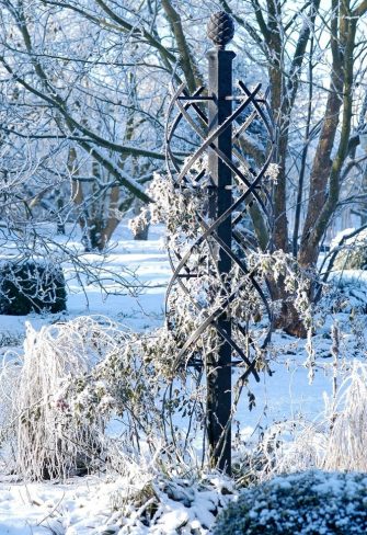 The Charleston Rose Obelisk covered in hoar frost in a snowy garden