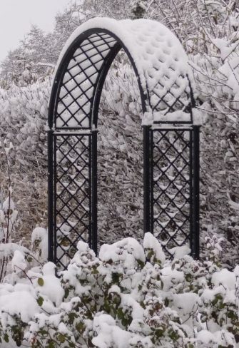 The Portofino Romanesque Garden Arch by Classic Garden Elements covered in snow