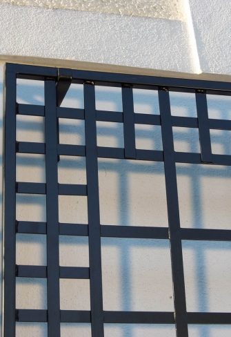 Close-up of the exclusive Poundbury Metal Wall Trellis by Classic Garden Elements, with wall hooks